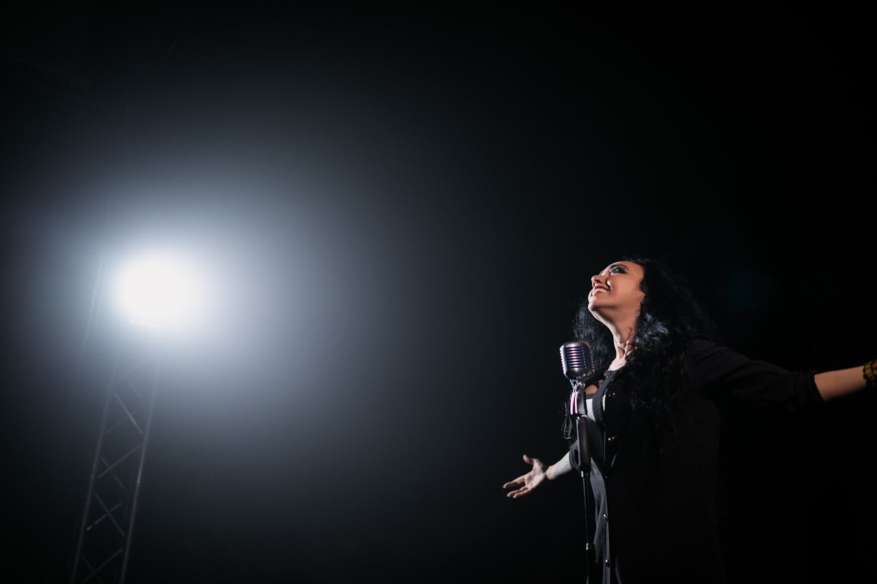 Mastering the First Impression: Your intriguing post title goes here A passionate female singer performs on stage under a dramatic spotlight.